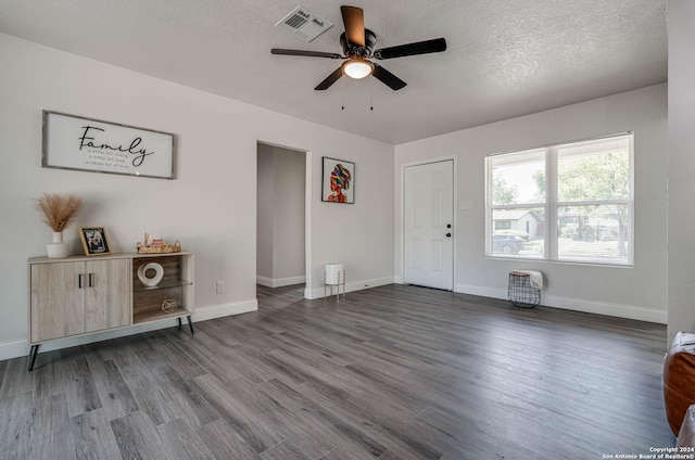 interior space featuring ceiling fan, a textured ceiling, and dark hardwood / wood-style flooring