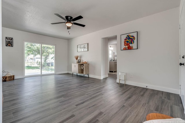 interior space featuring dark wood-type flooring, ceiling fan, and a textured ceiling