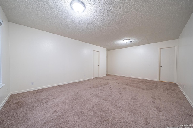 carpeted empty room with a textured ceiling