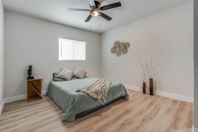 bedroom with light hardwood / wood-style floors and ceiling fan