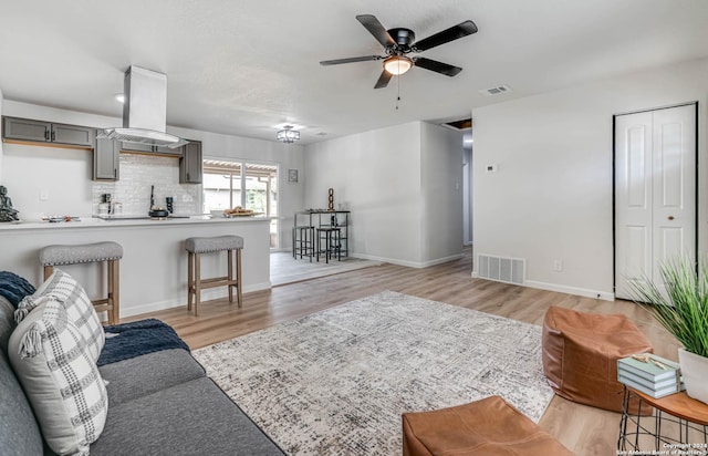 living room featuring ceiling fan and light wood-type flooring