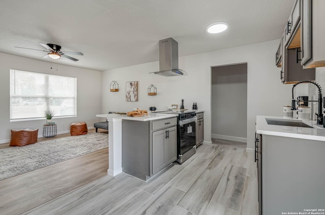 kitchen with sink, island range hood, electric range oven, light hardwood / wood-style flooring, and gray cabinets