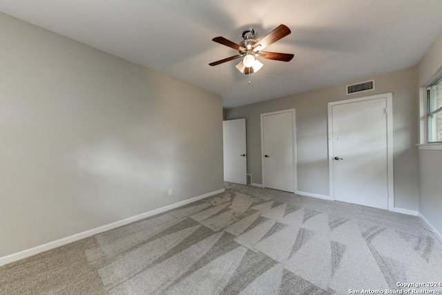 unfurnished bedroom featuring light colored carpet and ceiling fan