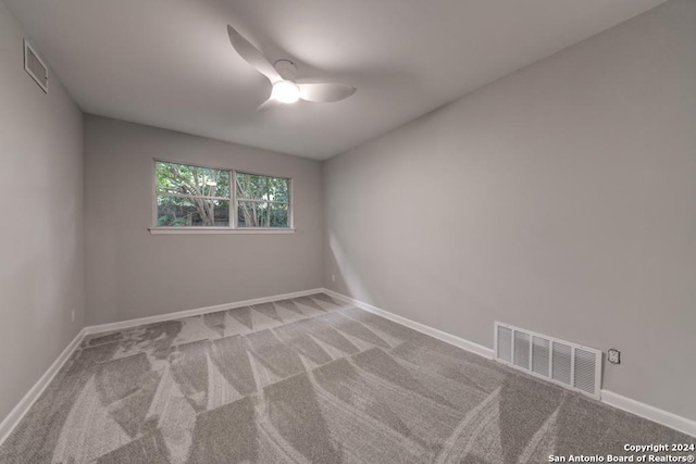 carpeted spare room featuring ceiling fan