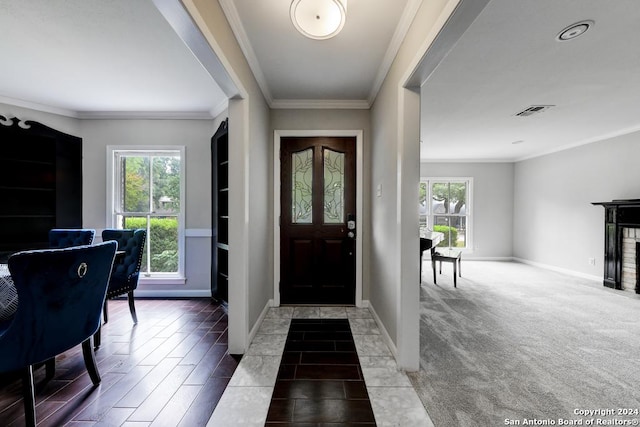 carpeted foyer featuring ornamental molding