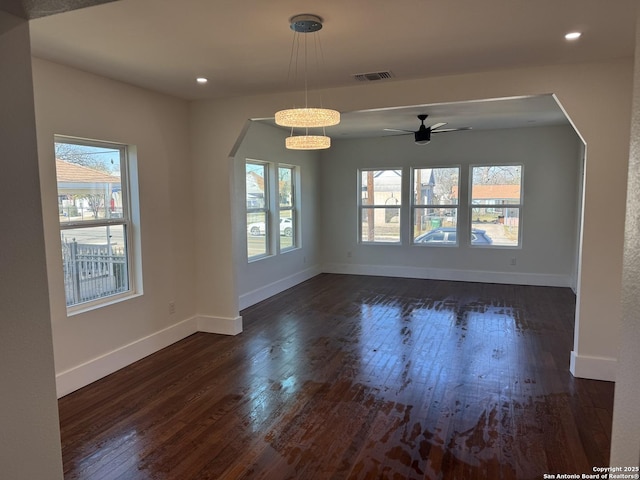 unfurnished dining area featuring ceiling fan, a healthy amount of sunlight, and dark hardwood / wood-style flooring