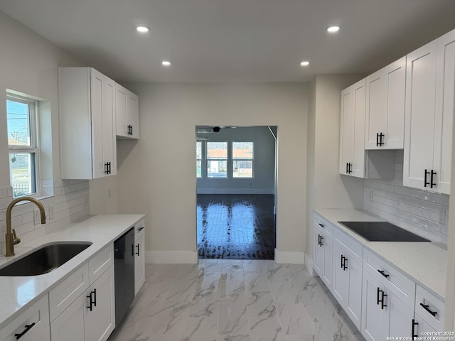 kitchen featuring light stone counters, black appliances, sink, and white cabinets