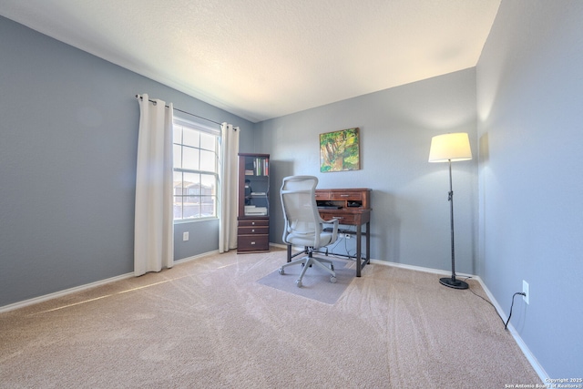 carpeted home office featuring a textured ceiling