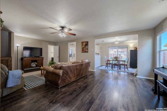 living room featuring ceiling fan, dark hardwood / wood-style flooring, and a textured ceiling