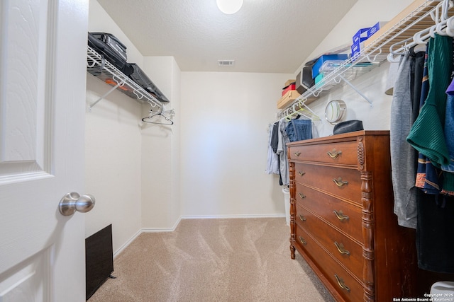 walk in closet featuring light colored carpet