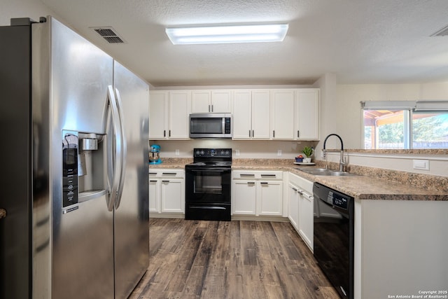 kitchen with dark hardwood / wood-style floors, white cabinetry, sink, black appliances, and a textured ceiling