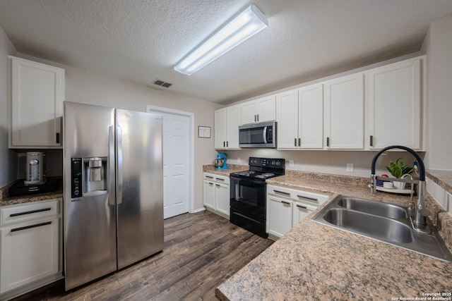 kitchen with dark wood-type flooring, sink, a textured ceiling, stainless steel appliances, and white cabinets