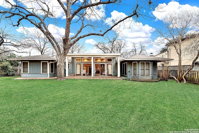 rear view of house featuring a lawn