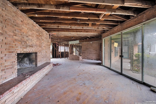 misc room featuring an outdoor brick fireplace, brick wall, and plenty of natural light