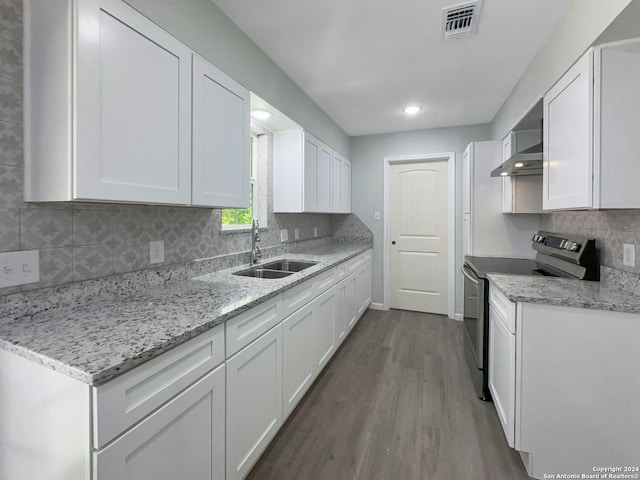 kitchen with white cabinetry, stainless steel electric stove, sink, and wall chimney range hood