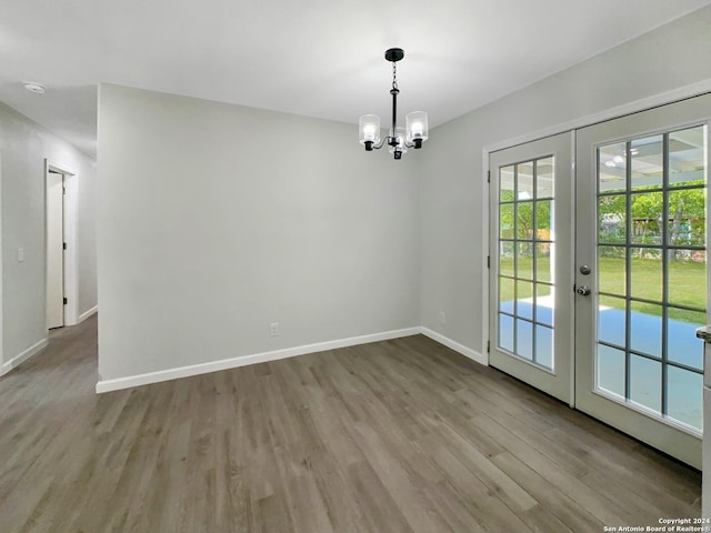 interior space featuring light hardwood / wood-style flooring, french doors, and a chandelier