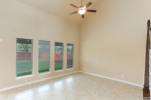 empty room with ceiling fan, light tile patterned flooring, and high vaulted ceiling