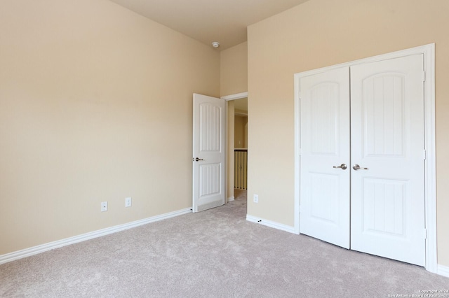 unfurnished bedroom with a closet and light carpet