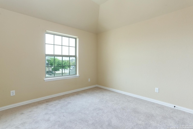 empty room with lofted ceiling and carpet flooring