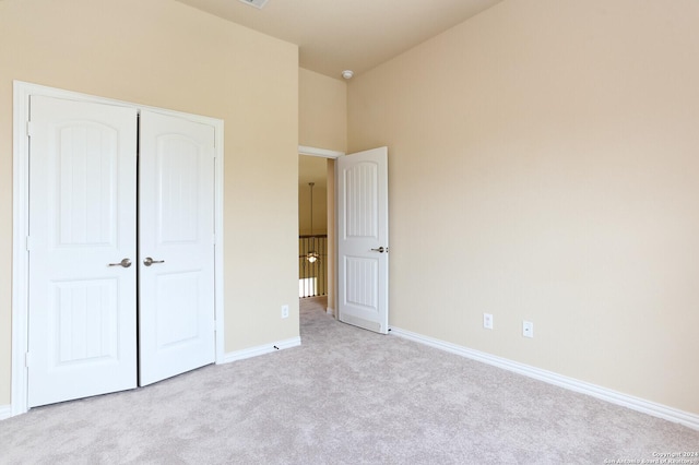 unfurnished bedroom featuring a closet and light carpet