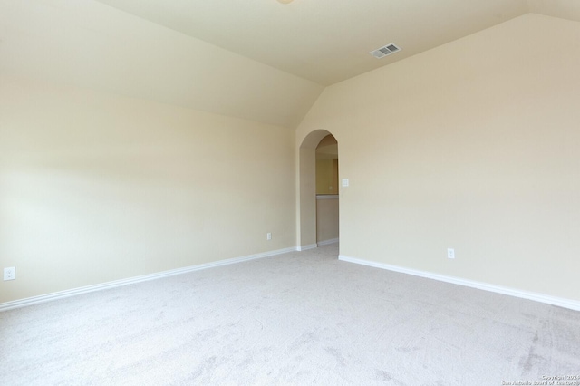 carpeted empty room featuring vaulted ceiling