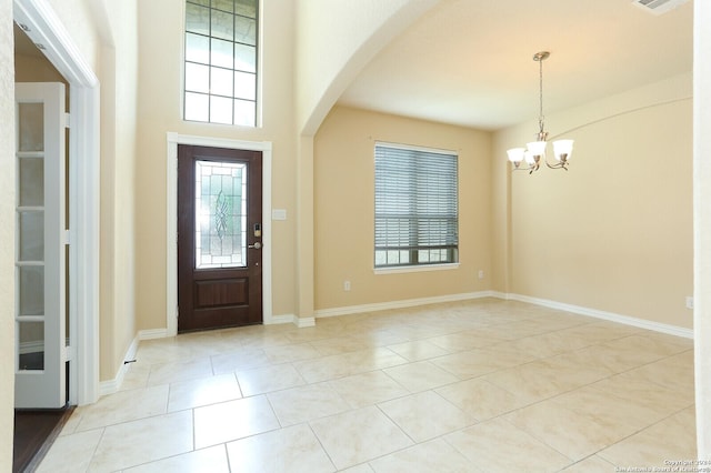 tiled foyer entrance with a chandelier