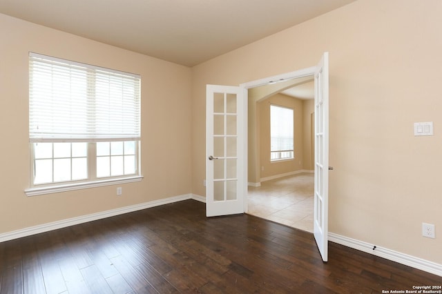 spare room with dark wood-type flooring and french doors