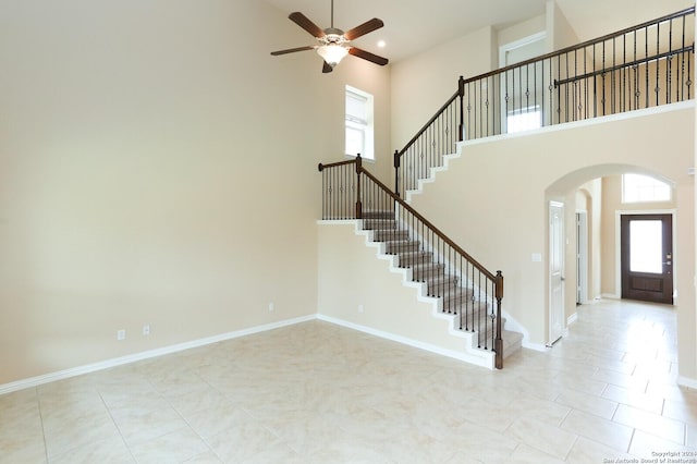 tiled foyer featuring a towering ceiling and ceiling fan