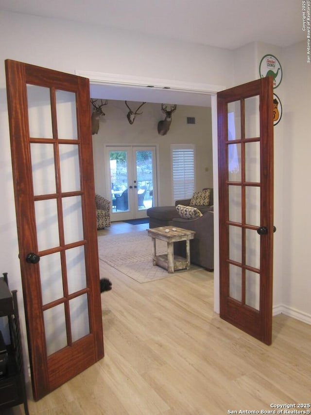 corridor featuring french doors and light wood-type flooring