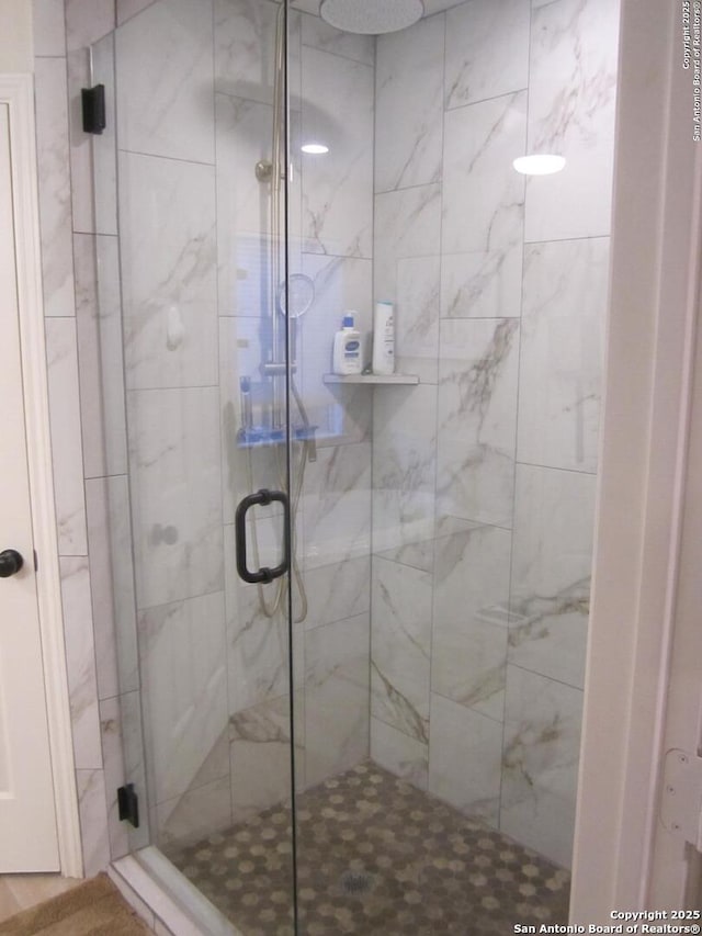 bathroom featuring a shower with shower door