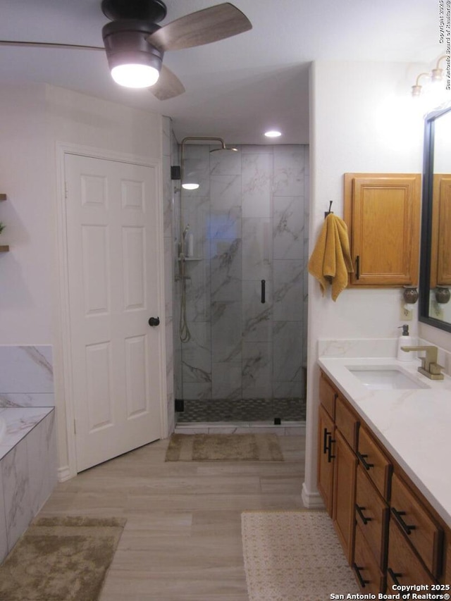 bathroom with vanity, wood-type flooring, ceiling fan, and a shower with shower door