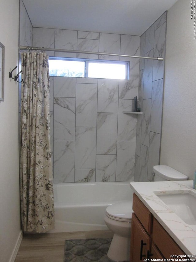 full bathroom featuring hardwood / wood-style flooring, shower / tub combo with curtain, vanity, and toilet