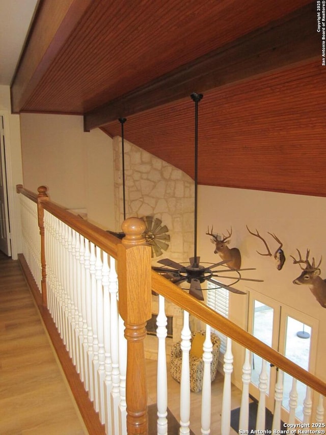 stairs with hardwood / wood-style flooring, ceiling fan, lofted ceiling with beams, and wooden ceiling