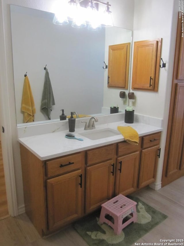 bathroom featuring vanity, a notable chandelier, and hardwood / wood-style floors