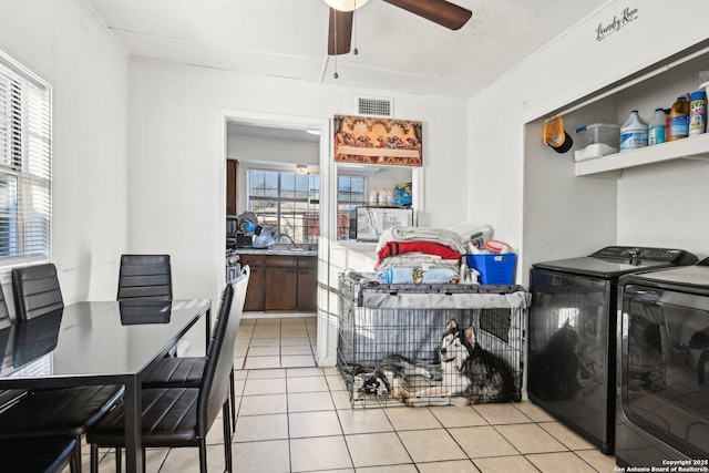 interior space with ceiling fan, light tile patterned floors, and washer and clothes dryer