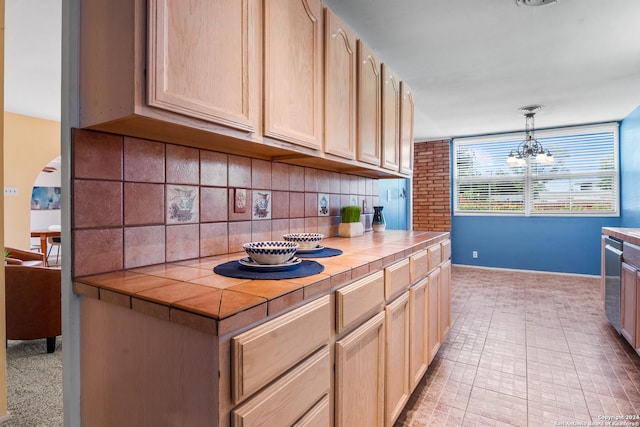 kitchen with dishwasher, hanging light fixtures, tasteful backsplash, tile counters, and light brown cabinetry