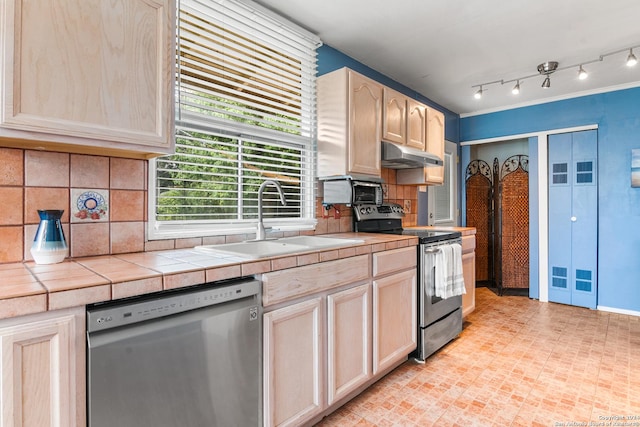 kitchen with tile countertops, light brown cabinetry, sink, backsplash, and stainless steel appliances