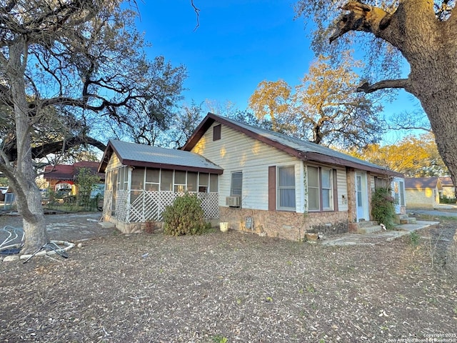 exterior space featuring a sunroom and cooling unit