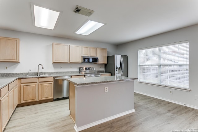 kitchen featuring sink, a center island, light hardwood / wood-style floors, stainless steel appliances, and light brown cabinets