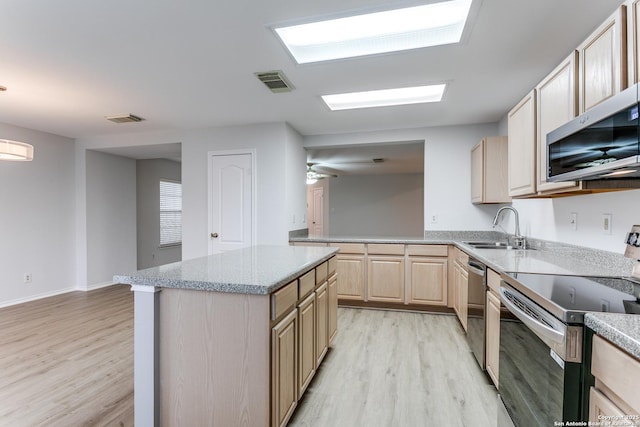 kitchen featuring sink, appliances with stainless steel finishes, a center island, light hardwood / wood-style floors, and light brown cabinetry