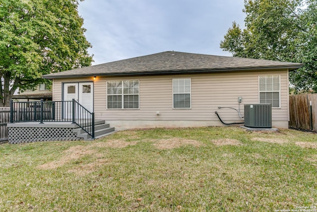 back of property with a wooden deck, a lawn, and central air condition unit