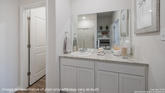 bathroom with a shower with door, vanity, and hardwood / wood-style flooring