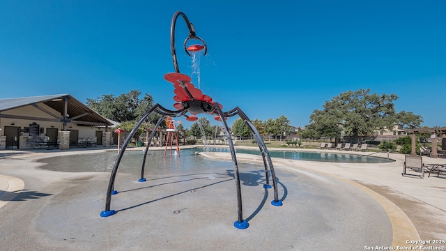 view of swimming pool featuring a playground