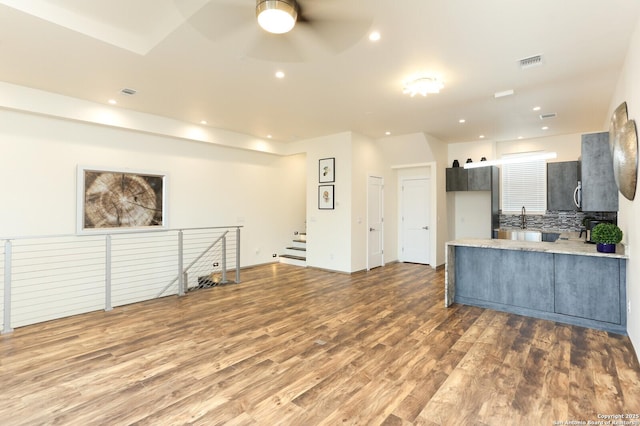 kitchen featuring dark wood-type flooring, ceiling fan, and kitchen peninsula