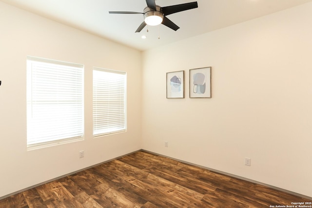 spare room featuring plenty of natural light, dark wood-type flooring, and ceiling fan