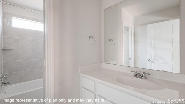 bathroom featuring tiled shower / bath combo and vanity