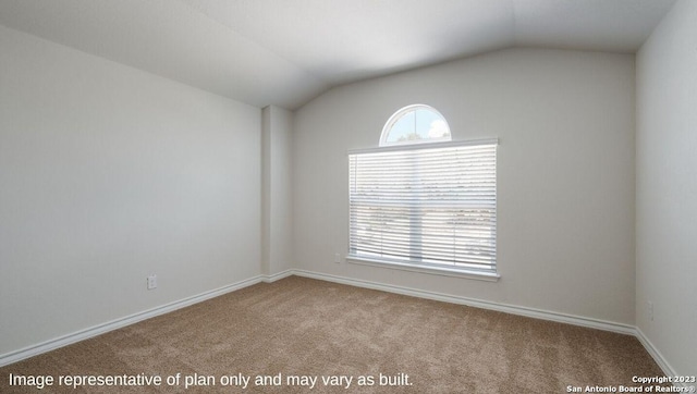 unfurnished room featuring light carpet and vaulted ceiling