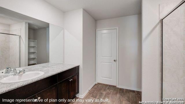 bathroom with vanity, hardwood / wood-style floors, and walk in shower