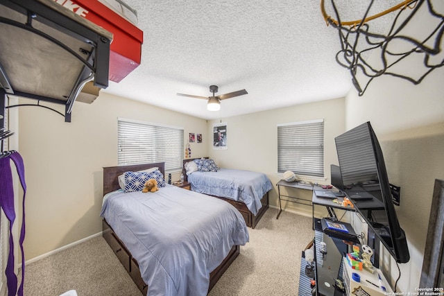 carpeted bedroom featuring ceiling fan and a textured ceiling