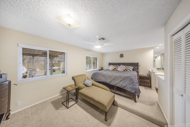 bedroom with ceiling fan, a closet, light carpet, and a textured ceiling